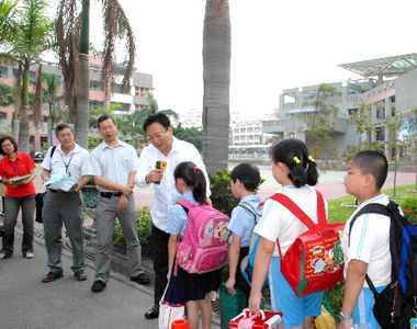 開學第一天卓伯源為小朋友量體溫(圖)