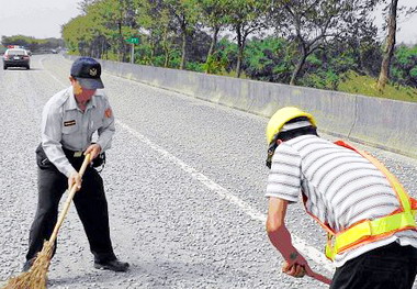 砂石車掉漏碎石為防止意外警投入掃除(圖)