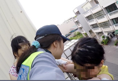女子驚險拾衣吊掛外牆警消防合力救援(圖)